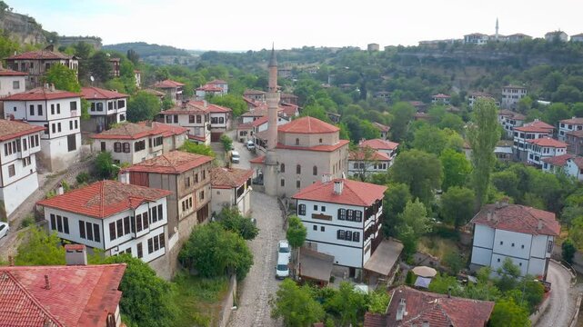 An impressive shot of the historic houses in Safranbolu Old Town, with the drone gliding past the elegant minaret of the Dağdelen Mosque and into the lush valley.