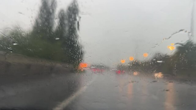 Driving in rain on motorway, windshield view, blurry, defocussed, background, driving plate, car front view.