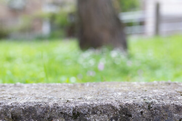 Stone empty table podium platform copy space with blurred background. Stone concrete table platform template mock up abstract outdoors background with grass and sun nature park background