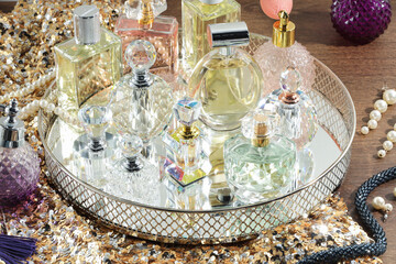 Different luxury perfumes and accessories on wooden table