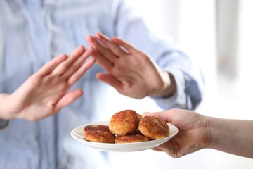 Woman refusing patties indoors, selective focus. Food allergy concept