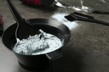 Mixing hair bleaching powder and developer on grey background, closeup