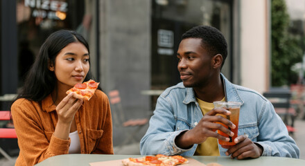Young asian female and african male enjoy outdoor pizza date