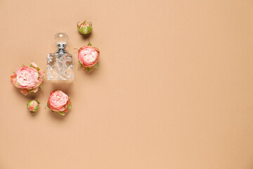 Flat lay composition with bottle of aromatic perfume and beautiful flowers on beige background. Space for text
