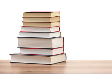 Stack of old books on wooden table against white background