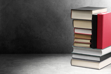 Old books on light grey table, space for text