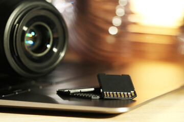 SD memory cards, laptop and photo camera on table, closeup