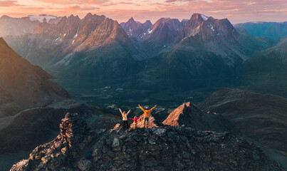 Naklejka premium Family climbing mountains in Norway - aerial view travel lifestyle mother, father, and child on the top adventure trip people on active summer vacations extreme tour outdoor in Lyngen Alps landscape
