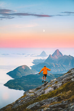 Travel in Norway - man hiking solo in mountains active adventure summer vacations, tourist exploring wild Scandinavian nature healthy lifestyle freedom concept islands and sea landscape moon and dawn