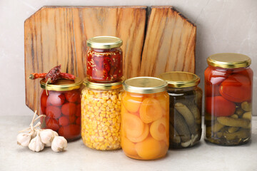 Many jars with different pickled products on light table