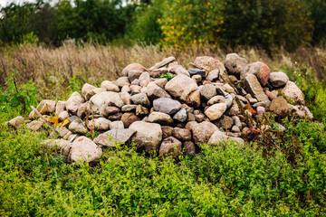 Pile of stones forming a small hill in a green field
