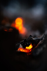 Smoldering embers in a campfire close-up, natural abstract background.