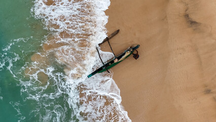 Local fisherman launches traditional boat from sandy beach in the Southern Sri Lanka—authentic coastal life