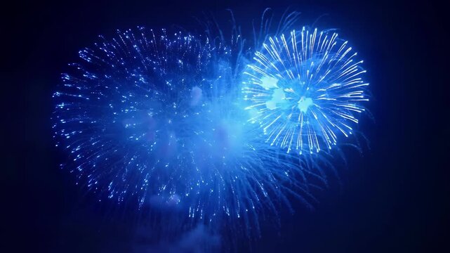 Vibrant blue fireworks bursting in the night sky, illuminating the darkness with intense colors and patterns