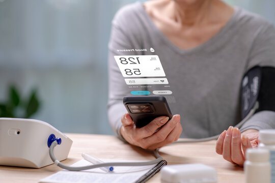 Senior Asian Woman taking blood pressure test on phone, in concept of Augmented reality, Application Interface design, UX UI design, and Health care - Powered by Adobe