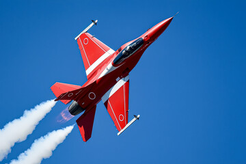 Red jet is flying through the sky