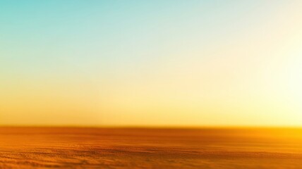 Obraz premium A serene horizon at sunset with a gradient sky transitioning from blue to warm orange tones over a vast, sandy landscape.