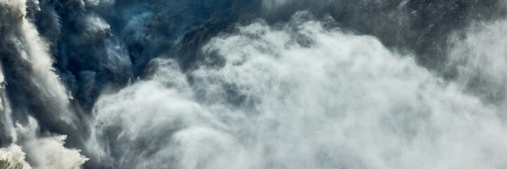 Obraz premium Dettifoss waterfall in Iceland. Powerful cascade of water plunging into a canyon in Iceland. Mist and spray rising from the falls. Natural power and scenic beauty.