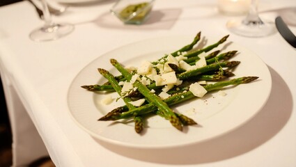 fine dining vegetable dish white plate elegant plating roasted asparagus gourmet food black pepper parmesan cheese asparagus spears
