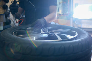 Mechanic pumping a wheel, close-up