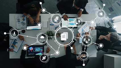 A team of professionals engaged in a dynamic management meeting surrounded by data visualizations and digital tools, fostering collaboration and innovative ideas in the workplace. Amity