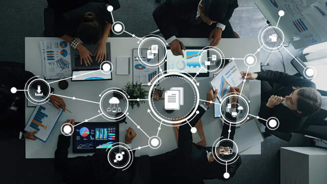 A team of professionals engaged in a dynamic management meeting surrounded by data visualizations and digital tools, fostering collaboration and innovative ideas in the workplace. Amity