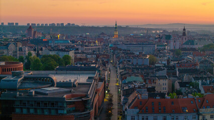 Obraz premium Cityscape of Poznań, Greater Poland, Poland — aerial top view of Polwiejska Street with the city hall visible in the distance at dusk.