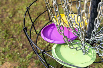 Black disc golf goal basket in field course