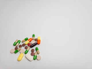 Assorted colorful pills and capsules on a white background