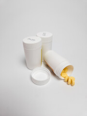 Pills spilling from prescription bottles on white background