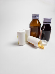 Medicine bottles and pills on white background