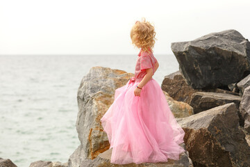 little girl in pink dress on the beach in summer