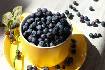 Yellow cup with ripe blueberries, close-up