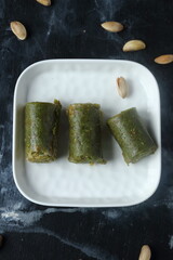 Pistachio Rolls baklava – Traditional Turkish Dessert on White Plate