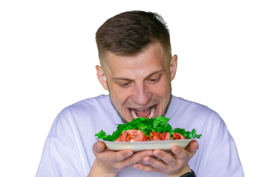 Bearded man in a white t-shirt joyfully pretending to eat a fresh vegetable salad with tomatoes and lettuce,  on a transparent background
