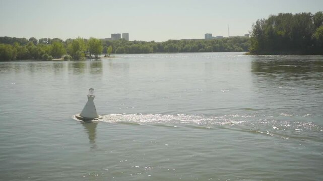 View from a boat floating past a buoy on the river.