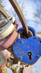 Blue metal padlock with inscription in Russian: advice and love. Tradition of hanging locks on wedding day and throwing away keys. Symbol of love and loyalty