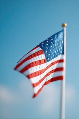 Obraz premium solitary american flag gently flutters against vast clear blue sky symbolizing memorial day remembrance