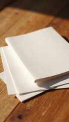 A stack of blank white sheets of paper resting on a warm, wooden surface, perfect for creative projects or minimalistic designs.