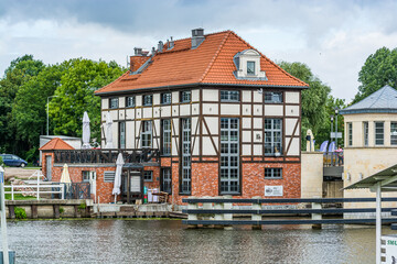 Elblag, Poland - August 17, 2021. Old house rebuilt to pub by Wysoki bridge by river Elblag