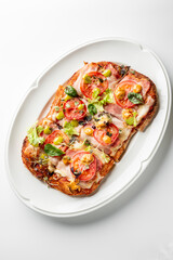 A delicious open-faced sandwich topped with melted cheese, fresh tomatoes, olives, and greens. This vibrant dish offers a delightful combination of flavors and textures.