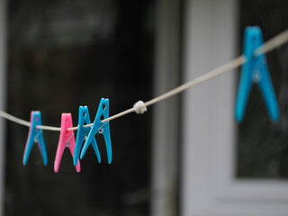 Close up of some colourful plastic, clothes pegs on a washing line