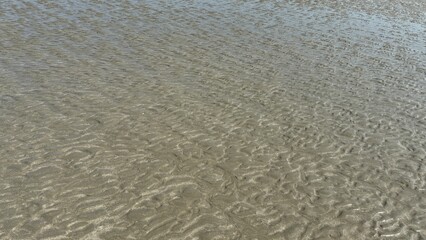 White sand beach texture with abstract blue water waves and natural surface reflection