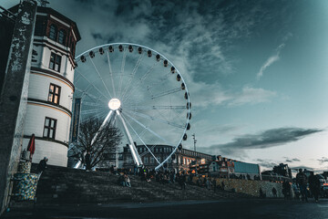 Ferris wheel in the city at dusk with urban surroundings. Editorial use only