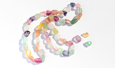 Fluorite natural colorful stones, mineral, beads of bracelet, necklace isolated on white background. Fluorspar stone gems, set of natural mineral stones, beautiful gemstones. Top view. 