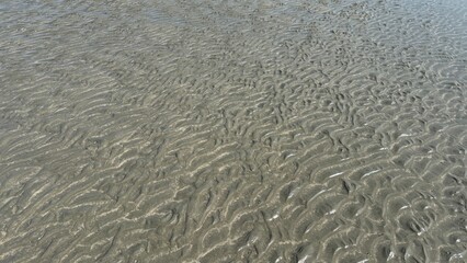 White sand beach texture with abstract blue water waves and natural surface reflection