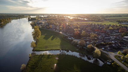 Fototapeta premium Appeltern, the Netherlands - April 19th 2025: Beautiful aerial photo of the village at sunset.