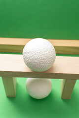 Still life with wooden blocks and a a plastic foam ball on green background	