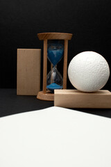 Still life with wooden blocks, hourglass and a a plastic foam ball	