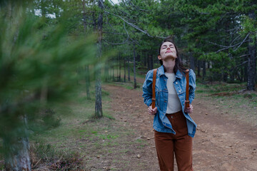 Hiker enjoying clean air in a forest, taking a deep breath during a trekking tour in the woods